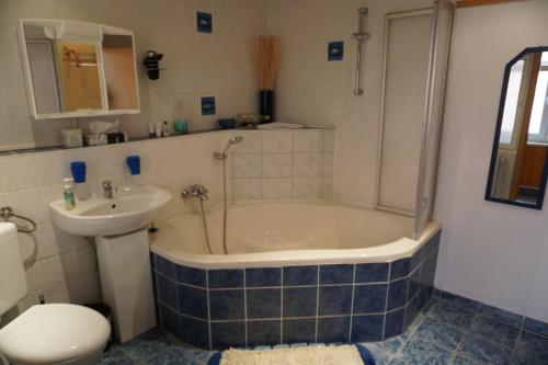 ein Badezimmer mit einer Badewanne, einem Waschbecken und einem WC in der Unterkunft Ferienwohnung Midgard in Thale