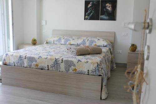 a bedroom with a bed with a blue and white blanket at M@re Nostrum & Co. in Campora San Giovanni