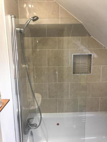 a shower with a glass door in a bathroom at Hunters Hide Apt in Littlehampton