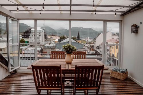 una sala da pranzo con tavolo, sedie e una grande finestra di Ushuaia Homes Downtown Apartments a Ushuaia
