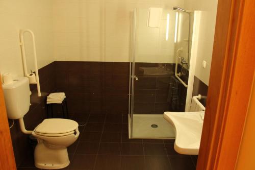 a bathroom with a toilet and a shower and a sink at Hotel Minho Belo in Vila Nova de Cerveira