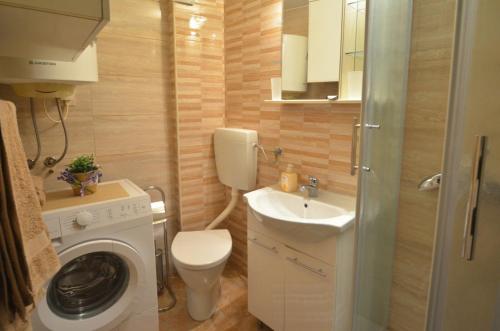 małą łazienkę z pralką i umywalką w obiekcie Apartment ALESSIA w Rovinj