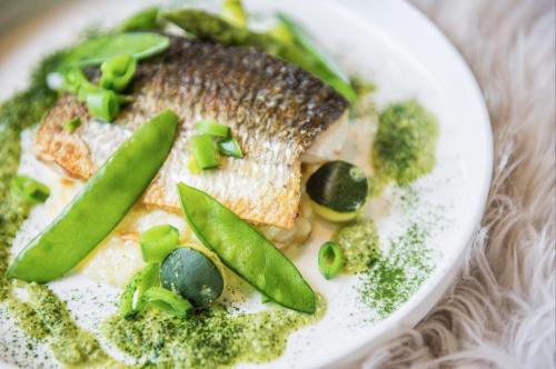 a plate of food with a piece of fish and broccoli at Prins Hendrik Texel in Oost