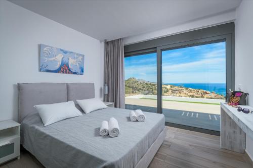 Villa Akrotiri في vlicha: غرفة نوم مع سرير وإطلالة على المحيط