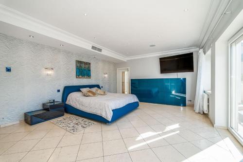 a bedroom with a blue bed and a large window at Villa SVIM, walking distance to the beach! in Marbella
