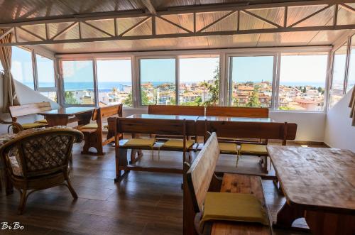 ソゾポルにあるDom Mladenoviのテーブルと椅子、窓のあるレストラン