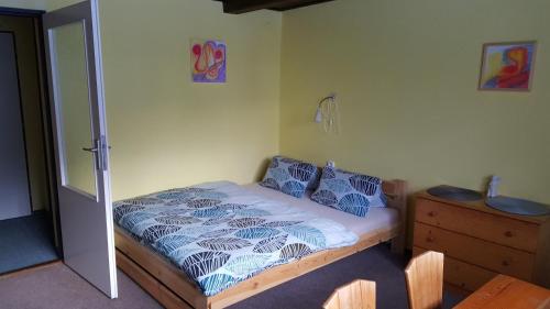 sypialnia z łóżkiem z niebieskimi poduszkami i komodą w obiekcie Chalupa 387 w mieście Harrachov