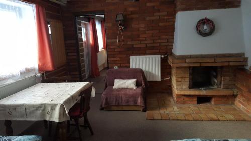 a living room with a table and a fireplace at Chalupa 387 in Harrachov