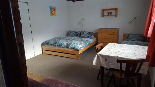 a small bedroom with a bed and a table at Chalupa 387 in Harrachov