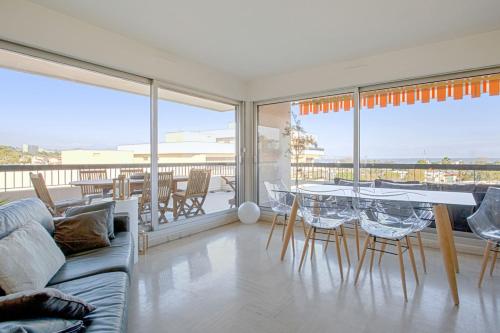 un salon avec un canapé, une table et des chaises dans l'établissement Appartement Panorama - Welkeys, à Villeneuve-Loubet