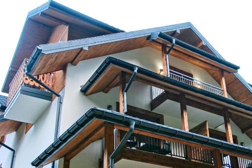 a building with wooden balconies on the side of it at Apartamenty Magia Gór in Szczawnica