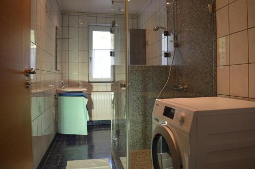 オッペナウにあるFerienwohnung im Herzen des Renchtalsのバスルーム(シャワー付)の洗濯機が備わります。