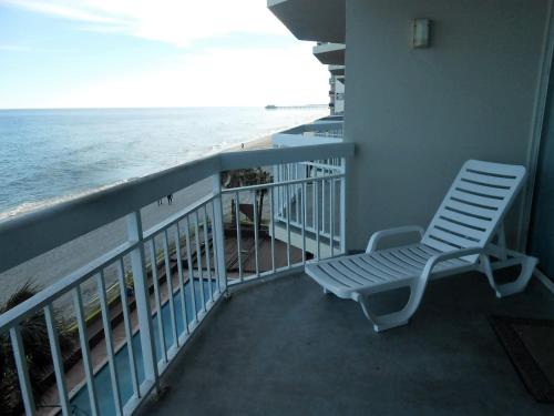 a chair sitting on a balcony looking at the ocean at 0308 Waters Edge Resort condo in Myrtle Beach