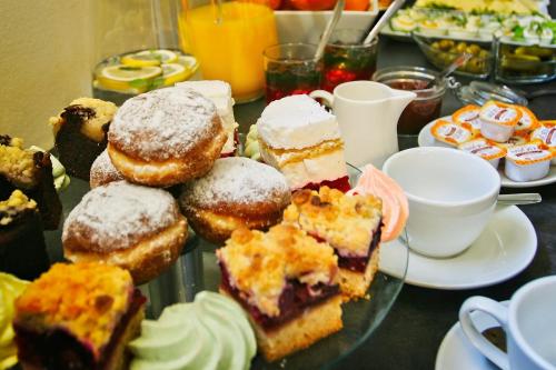 a tray of pastries on a table with cups of coffee at Apartamenty Magia Gór in Szczawnica