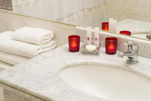 a bathroom with a sink with candles and a mirror at Hotel Don Eduardo in Temuco