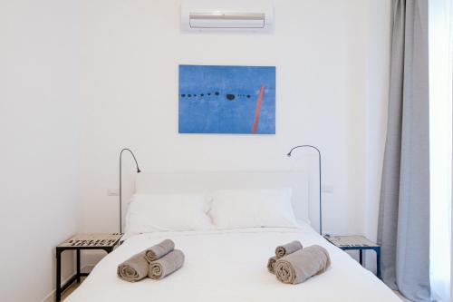 ein Schlafzimmer mit einem weißen Bett und Handtüchern darauf in der Unterkunft Borgovico Garden - The House Of Travelers in Como