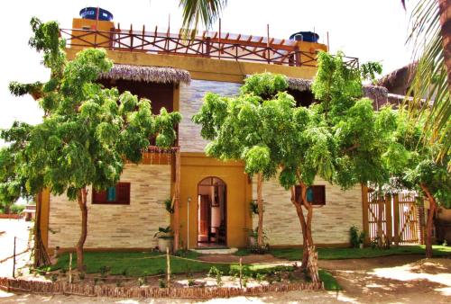 a house with two trees in front of it at Residencial Bem-te-vi in Jericoacoara