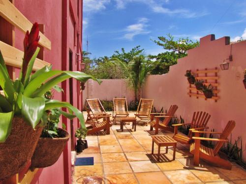 a patio with chairs and tables on a pink building at Residencial Bem-te-vi in Jericoacoara