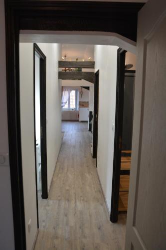 an empty hallway with white walls and wood floors at Ferme les Iris in Issenheim