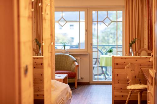 a bedroom with a view of a balcony at Aktiv & Wellnesshotel Zentral in Prato allo Stelvio