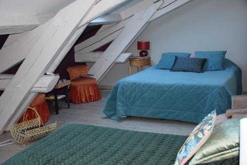 a attic bedroom with a bed and a staircase at CLOCHI-CLOCHA in Montbrison