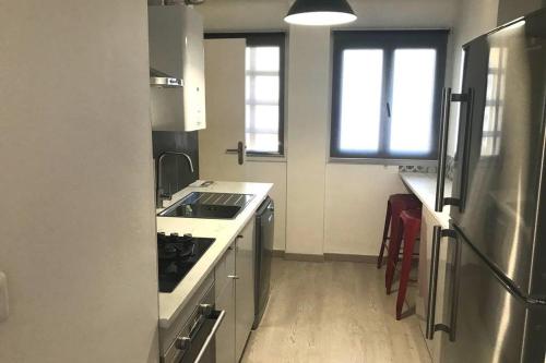 Il comprend une petite cuisine équipée d'une cuisinière et d'un réfrigérateur. dans l'établissement Bel appartement T3 Mourillon à 5 min des Plages - vue mer, à Toulon