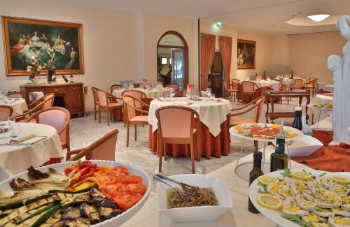 a dining room with tables and plates of food at Best Western Hotel Globus City in Forlì