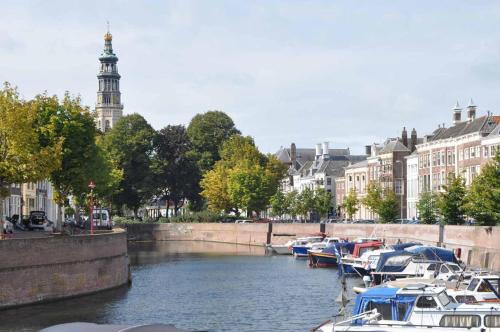 a group of boats docked in a river with buildings at Hotel Middelburg in Middelburg
