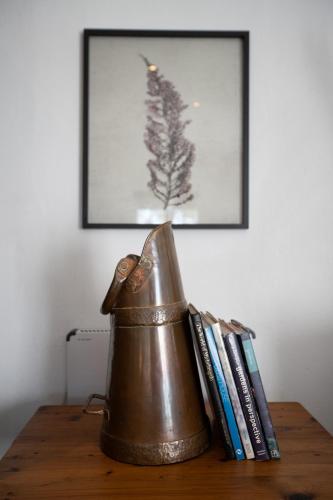 a bronze tea kettle sitting on a table with books at Kogman & Keisie Guest Farm in Montagu
