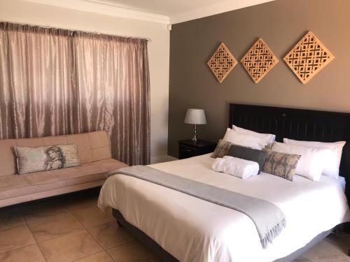a bedroom with a large bed and a couch at Bird's View in Hermanus