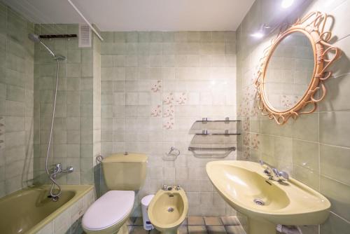 een badkamer met een wastafel, een toilet en een spiegel bij Apartment Meritxell in L'Escala