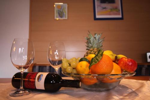 a bowl of fruit on a table with two wine glasses at Haus Ladner in See