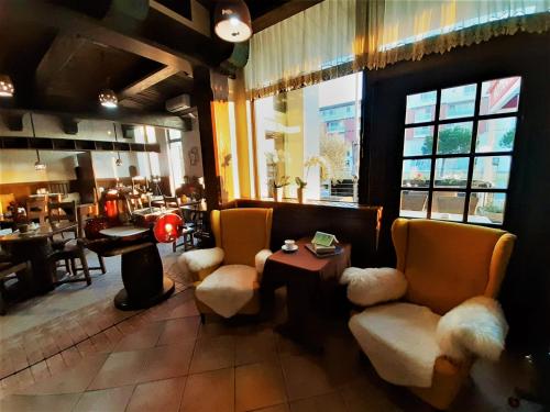 a restaurant with chairs and a table and a piano at Hotel Vodisek in Koper