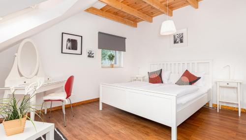 a white bedroom with a white bed and a desk at Hotel Rutherbach in Essen