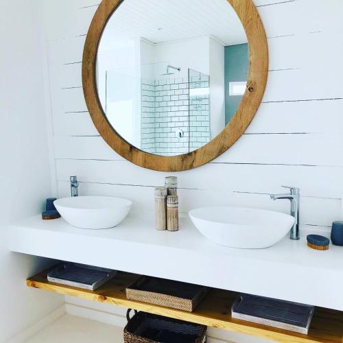 a bathroom with two sinks and a mirror on the wall at Seascape in De Kelders