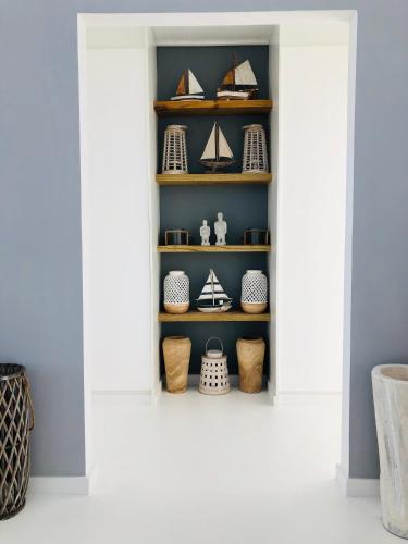 a room with a shelf filled with vessels at Seascape in De Kelders