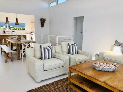 a living room with two chairs and a coffee table at Seascape in De Kelders