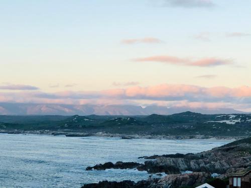 a view of the ocean with mountains in the background at Seascape in De Kelders