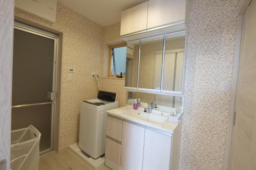 Un baño con lavabo y lavadora. en LN05 New Home in Sannomiya with Own Car Park, en Kobe