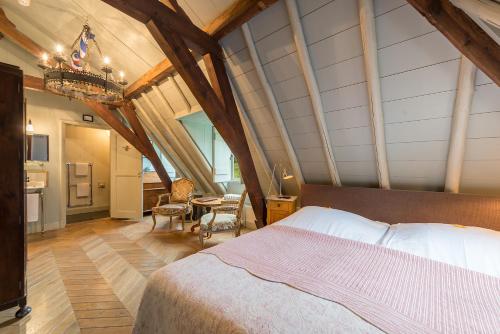 an attic bedroom with a bed and a kitchen at Logement Swaenenvecht in Utrecht