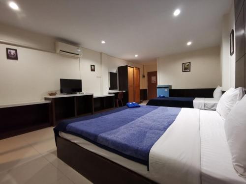 una camera d'albergo con due letti e una televisione di Ban Kaew Guesthouse Songkhla a Songkhla