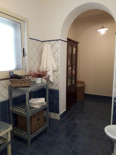 a bathroom with a blue tiled floor and a mirror at La Melagrana in Arenella