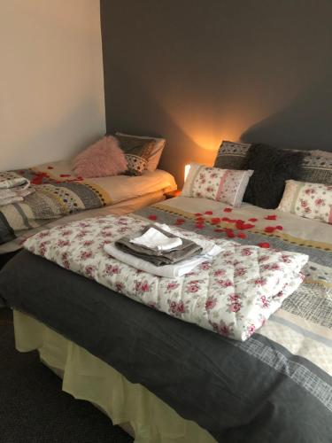 two beds sitting next to each other in a room at PondeROSEa Cottage Free Gated Parking M1 & City location, wood stove in Lisburn