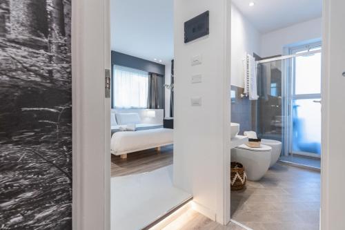 a bathroom with a toilet and a bedroom at Sicily 4 Suite in Catania