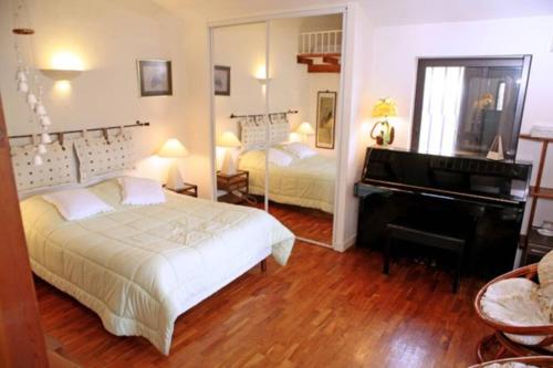 - une chambre avec deux lits et un piano dans l'établissement La Cigalière, à Valbonne