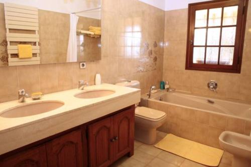 une salle de bain avec deux lavabos et une baignoire et des toilettes dans l'établissement La Cigalière, à Valbonne