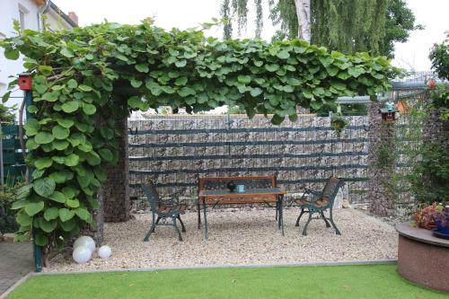 a bench and chairs in a garden with a wall at Ferienwohnung Halberstadt in Halberstadt