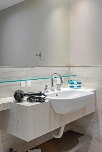 a bathroom with a sink and a mirror at Slaviero Baia Norte Florianópolis in Florianópolis