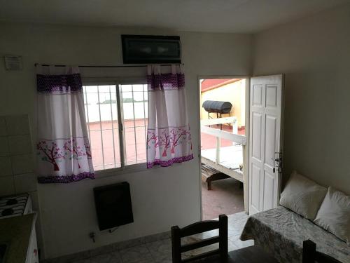 a room with a bed and a window and a television at Casa duplex Frente AL Mar familiar Depto A in Mar del Plata