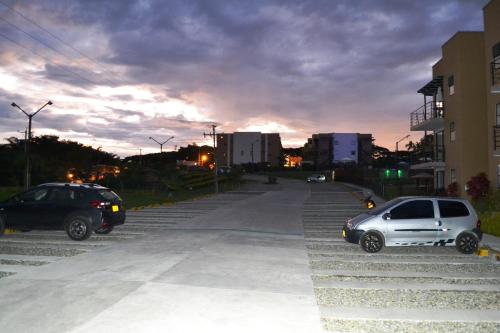 two cars parked in a parking lot at dusk at ApartaSol Reserva de la Colina in La Tebaida